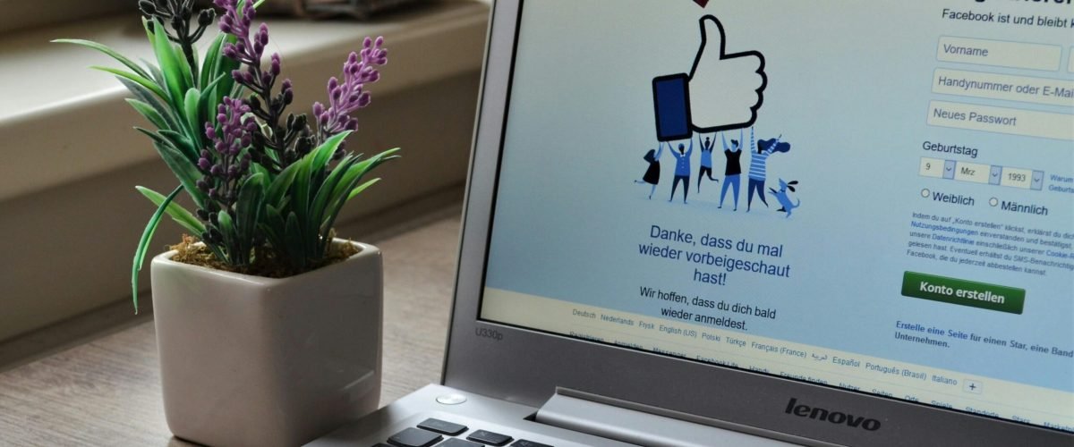 pexels-photo-927629-927629 A Lenovo laptop displaying Facebook login beside a lavender plant indoors.